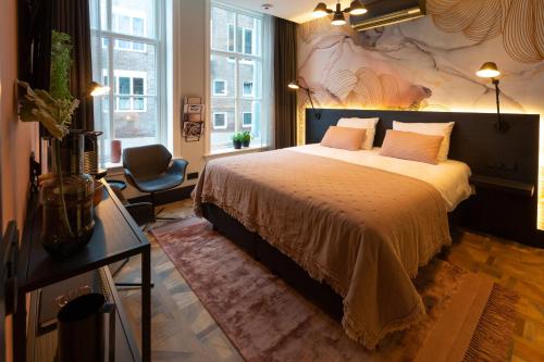 a bedroom with a large bed and a chair at Boutiquehotel Princenjagt in Middelburg