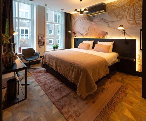 sypialnia z dużym łóżkiem i krzesłem w obiekcie Boutiquehotel Princenjagt w mieście Middelburg