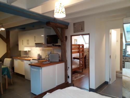 une cuisine avec des armoires blanches et une table dans une pièce dans l'établissement Gîte La Bulle En Baie, proche Mont Saint-Michel, au calme, pour 4 pers, à Crollon