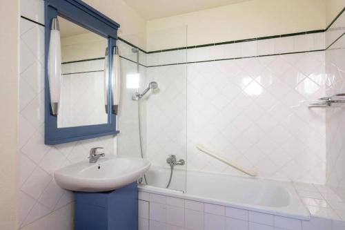 a bathroom with a sink and a shower with a mirror at Maison sur golf avec piscine chauffée à Lacanau Océan in Lacanau