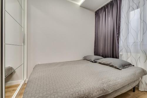 a bedroom with a bed in a white room at Central Platinum Apartments 16 in Rybnik