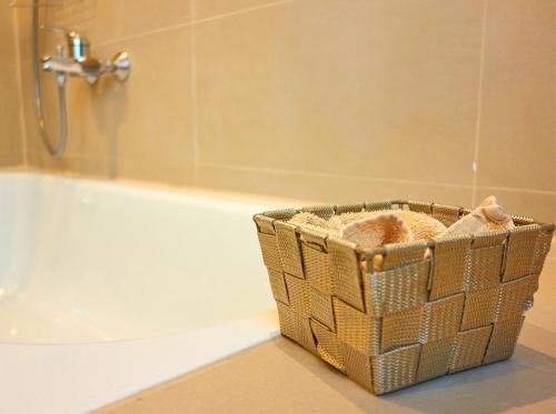 El baño incluye una cesta de toallas junto a la bañera. en Apartments Ho30 en Stuttgart