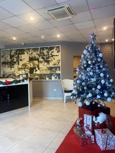 a christmas tree in an office with presents at Eracle Hotel in Volla