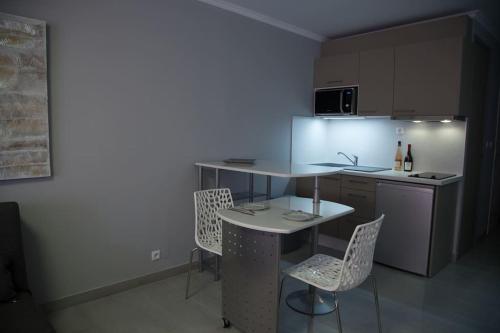 a kitchen with a table and chairs in a room at Stylish Studio in only 50 meters from beach ! in Nice