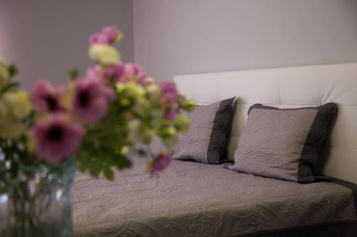 a vase filled with flowers sitting next to a bed at Stylish Studio in only 50 meters from beach ! in Nice