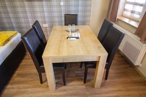 a dining room table with black chairs and a wooden table at Radics Panzió Étterem és Pihenő Központ in Letenye
