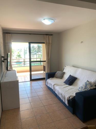 une chambre avec un lit et une grande fenêtre dans l'établissement Apartamento no Aquaville Resort, do lado da sombra e perto da praia, à Aquiraz