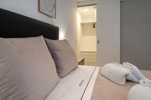 a white bed with a white towel on it at Moontels Paseo de Ruzafa in Valencia