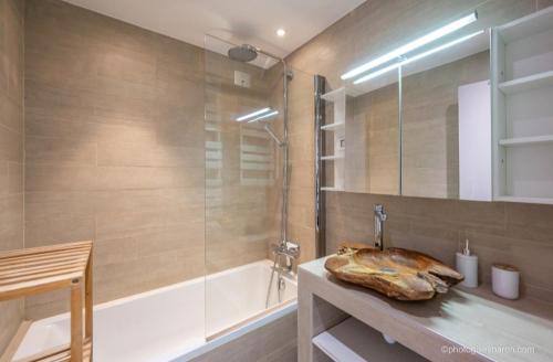 a bathroom with a shower and a sink and a tub at Appartement Queyrelet Orcières in Orcières