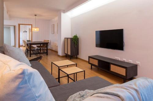 a living room with a couch and a flat screen tv at Moontels Paseo de Ruzafa in Valencia