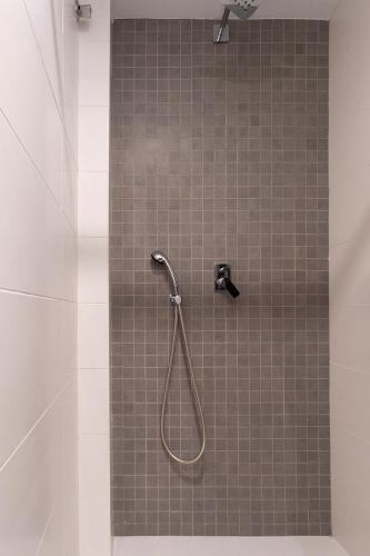 a shower with a hose in a bathroom at Moontels Paseo de Ruzafa in Valencia