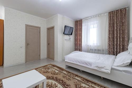 a bedroom with a bed and a tv in it at Apartments 7 Я-21/5-39 in Astana