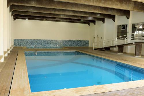 a large swimming pool with blue water in a building at Hotel Majestic in Águas de Lindóia