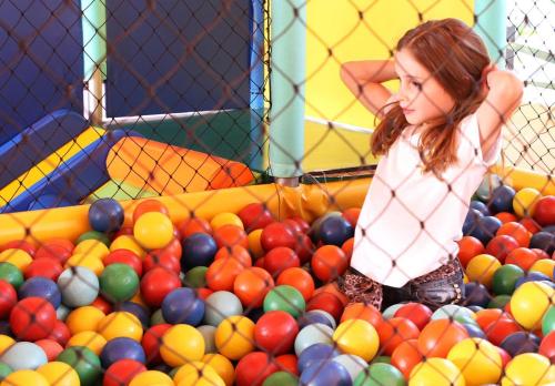 a young girl standing in a pile of balls at Hotel Majestic in Águas de Lindóia