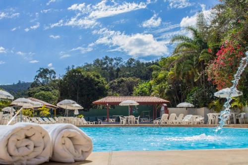 uma piscina num resort com uma fonte em Hotel Majestic em Águas de Lindoia