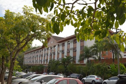 a large building with cars parked in a parking lot at Hotel Majestic in Águas de Lindóia