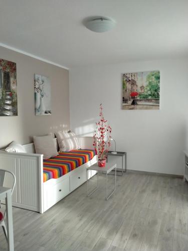 een witte kamer met een bed en een kleurrijke gestreepte bank bij La Casa De MarcoQ in Costa Calma