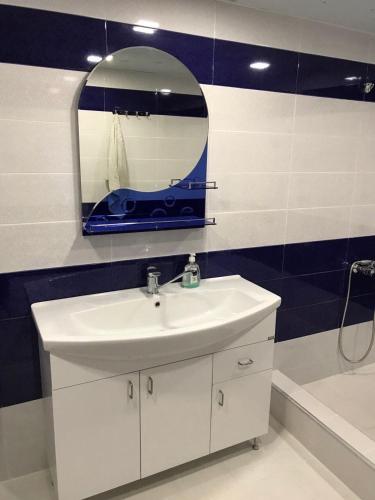 a bathroom with a sink and a mirror and a tub at Friend's House rooms near Airport in Yerevan