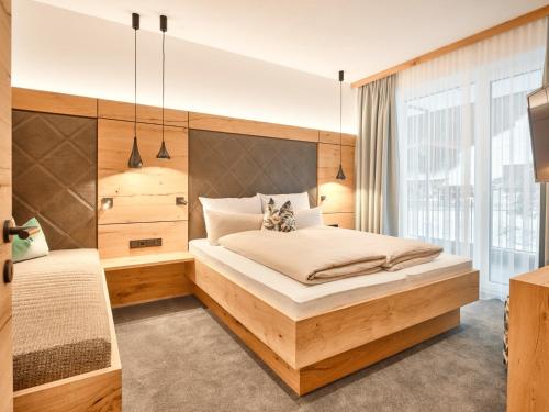 a bedroom with a large bed and a large window at Sun Lodge in Ischgl