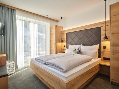 a bedroom with a large bed and a large window at Sun Lodge in Ischgl