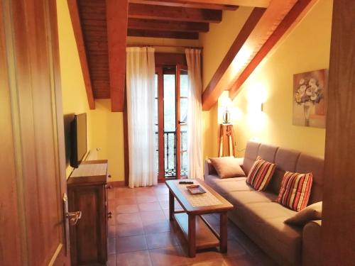 een woonkamer met een bank en een tafel bij Apartamentos Rurales La Viña in Cangas de Onís