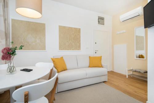 a living room with a white couch and a table at Cozy apartments in Ljubljana