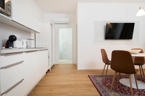 a kitchen with a table and chairs and a tv at Cozy apartments in Ljubljana
