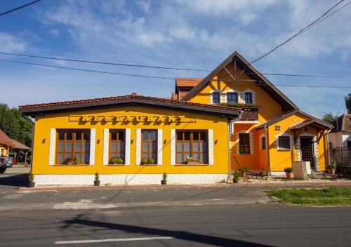 Radics Panzió Étterem és Pihenő Központ في ليتني: مبنى اصفر على جانب شارع