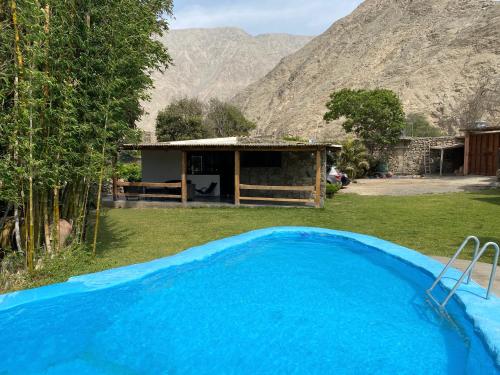 una piscina azul en un patio con una casa en Las Cabañas de Incahuasi, en Lunahuaná