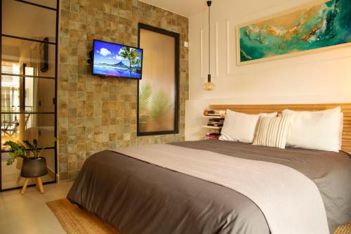 una camera con letto e TV su un muro di mattoni di Soho #1 Luxurious apartment in Saint Nicolas ad Ágios Nikólaos