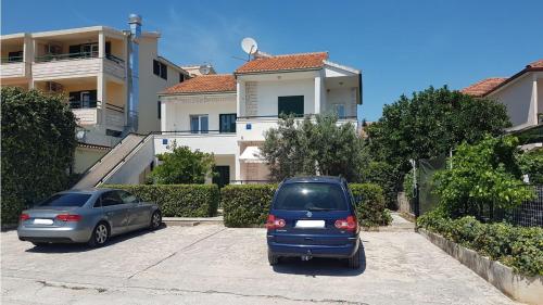 two cars parked in a parking lot in front of a house at Villa Radic in Poljica