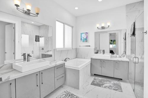 a white bathroom with two sinks and a mirror at Mimosa Sunrise Villa in Pompano Beach