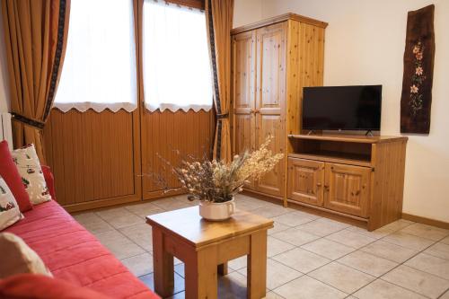 a living room with a red couch and a tv at lareit appartamenti in Bormio
