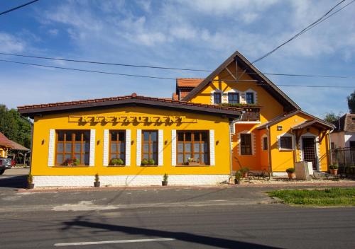 a yellow building on the side of a street at Radics Panzió Étterem és Pihenő Központ in Letenye