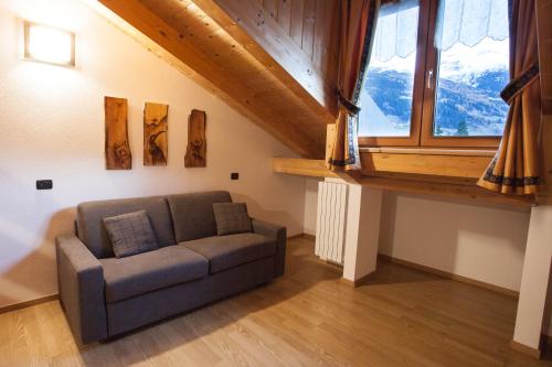 a living room with a couch and a large window at lareit appartamenti in Bormio
