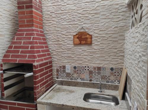 瓜拉派瑞Casa em Guarapari, próximo a praia do morro的厨房配有水槽和砖炉