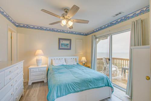 een slaapkamer met een bed en een plafondventilator bij 1 Anchors Away Oceanfront in Holden Beach
