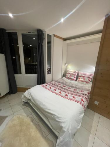 une chambre avec un lit dans une pièce avec une fenêtre dans l'établissement L'aiguille de L'M, à Chamonix-Mont-Blanc