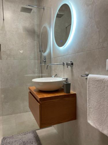 y baño con lavabo y espejo. en Proper Apartment 1, en Tirana