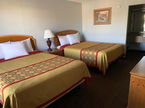 a hotel room with two beds and a lamp at Pigeon Forge Parkway Inn in Pigeon Forge