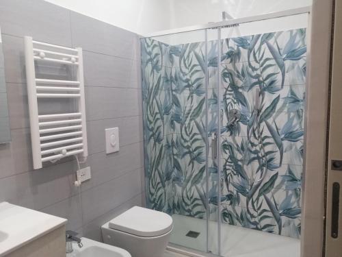 a bathroom with a shower curtain and a toilet at Albachiara suite in Trani