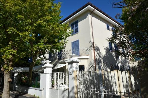 a white house with a fence at Petit Hotel in Lido di Camaiore