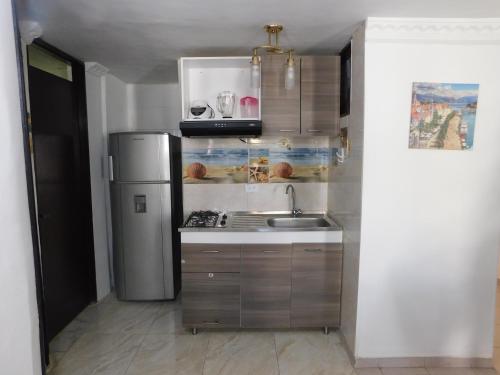a kitchen with a refrigerator and a sink at El Velero Apartamentos By DANP in Santa Marta