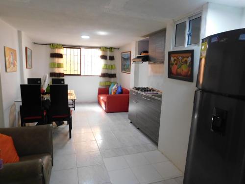 a kitchen with a refrigerator and a living room at El Velero Apartamentos By DANP in Santa Marta
