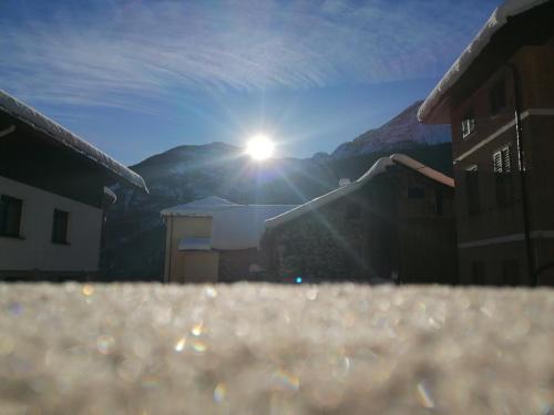 a view of the sun shining on a building at L'inizio... in Val di Zoldo