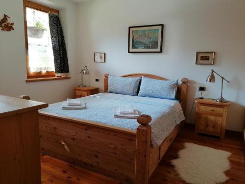 a bedroom with a wooden bed with blue pillows at L'inizio... in Val di Zoldo
