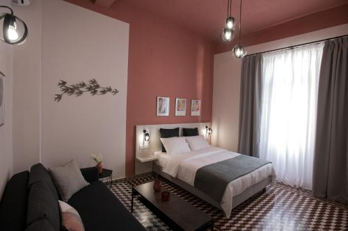 een slaapkamer met een bed en een bank bij Elegant apartment in the heart of Heraklion in Heraklion
