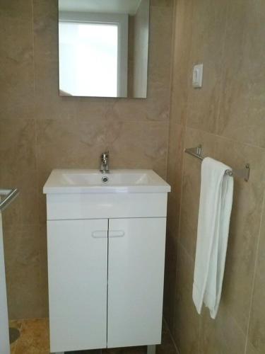 a bathroom with a white sink and a mirror at Studios Greenside in Coimbra