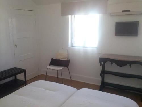 a bedroom with two beds and a desk and a window at Studios Greenside in Coimbra