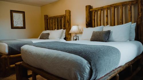 two beds in a hotel room with two beds sidx sidx sidx at Ouray Riverside Resort - Inn & Cabins in Ouray